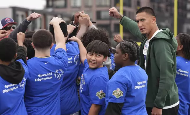 Draft prospect Tetairoa McMillan, right, a wide receiver from Arizona, works with local youth football players and Special Olympics athletes during the league's annual prospect clinic ahead of the NFL football draft Wednesday, April 23, 2025, in Green Bay, Wis. (AP Photo/Jeff Roberson)