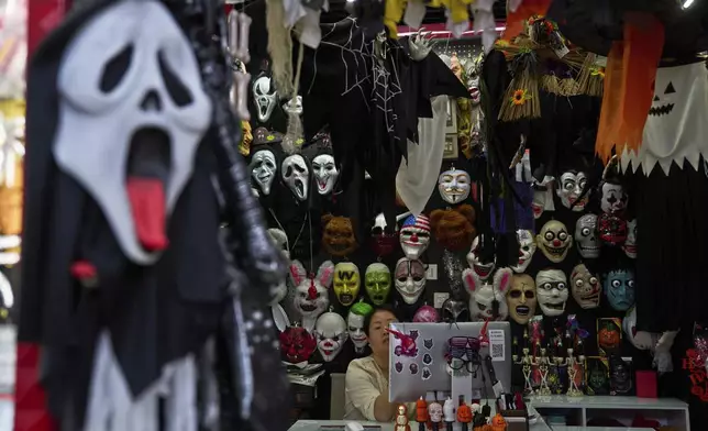 A vendor of halloween costumes wait for customers at the Yiwu International Trade Market in Yiwu, eastern China's Zhejiang province, Thursday, April 10, 2025. (AP Photo/Ng Han Guan)