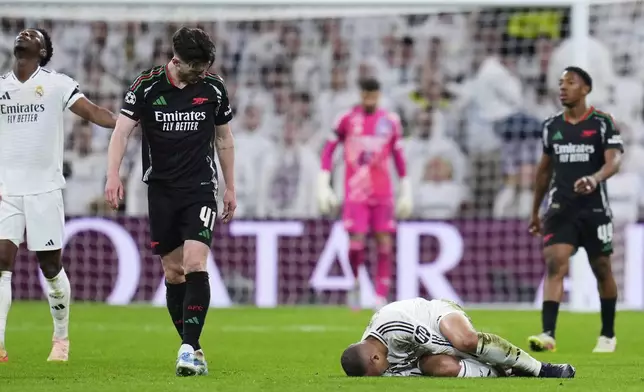 Arsenal's Declan Rice looks at Real Madrid's Kylian Mbappe on the ground after getting injured during the Champions League quarterfinals second leg soccer match between Real Madrid and Arsenal at the Santiago Bernabeu stadium in Madrid, Wednesday, April 16, 2025. (AP Photo/Manu Fernandez)