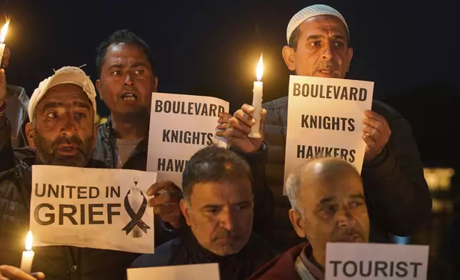 Kashmiri men hold candles and placards as they condemn the tourists killing during a protest in Srinagar, Indian controlled Kashmir, Thursday, April. 24, 2025. (AP Photo/Dar Yasin)