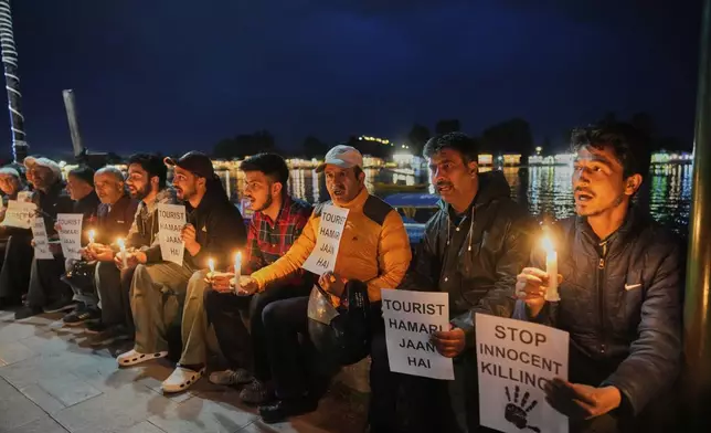 Kashmiri men hold candles and placards as they condemn the tourists killing during a protest in Srinagar, Indian controlled Kashmir, Thursday, April. 24, 2025. (AP Photo/Dar Yasin)