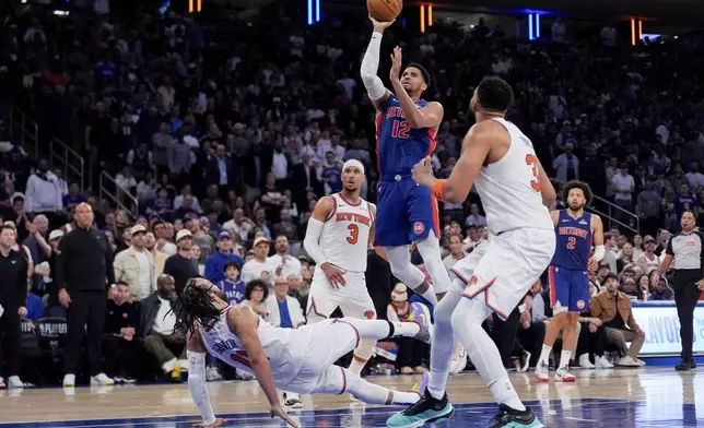 New York Knicks guard Jalen Brunson (11) falls as Detroit Pistons forward Tobias Harris (12) shoots during the second half of Game 1 in an NBA basketball first-round playoff series, Saturday, April 19, 2025, in New York. (AP Photo/Julia Demaree Nikhinson)