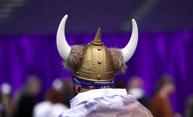 A fan wears a helmet during the Minnesota Vikings NFL football draft party Thursday, April 24, 2025, in Minneapolis. (AP Photo/Ellen Schmidt)