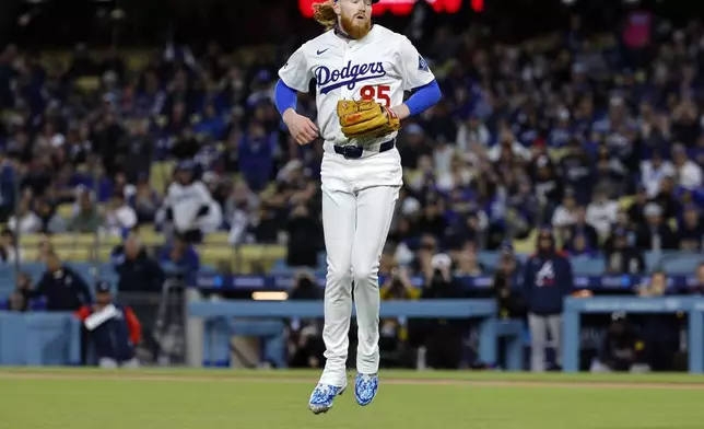 Los Angeles Dodgers' Dustin May jumps in the air after striking out the side against the Atlanta Braves during the first inning of a baseball game Tuesday, April 1, 2025, in Los Angeles. (AP Photo/Kevork Djansezian)