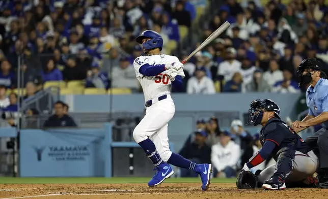 Los Angeles Dodgers' Mookie Betts hits a two-run home run against the Atlanta Braves during the sixth inning of a baseball game Tuesday, April 1, 2025, in, Los Angeles. (AP Photo/Kevork Djansezian)