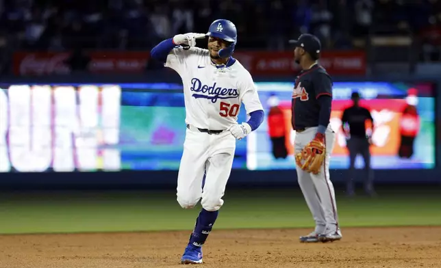 Los Angeles Dodgers' Mookie Betts celebrates after hitting a two-run home run against the Atlanta Braves during the sixth inning of a baseball game Tuesday, April 1, 2025, in, Los Angeles. (AP Photo/Kevork Djansezian)