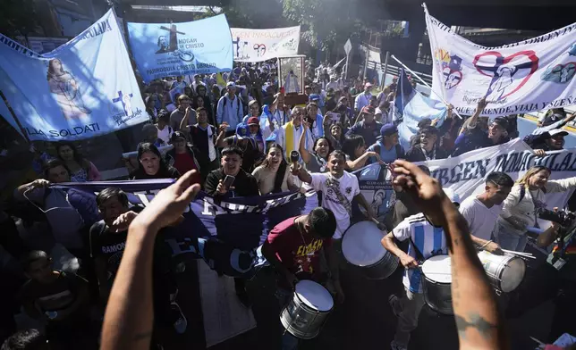 Mourners pay tribute to the late Pope Francis as they caravan through emblematic places of his life in Buenos Aires, Argentina, Saturday, April 26, 2025, on the day of his funeral in Rome. (AP Photo/Natacha Pisarenko)