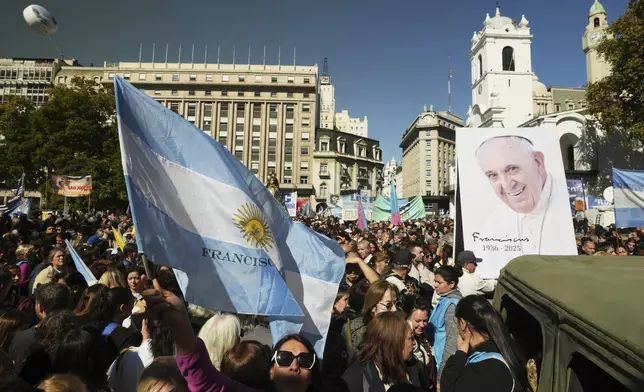 A mourner holds an Argentine flag as she pays tribute to the late Pope Francis outside the Cathedral in Buenos Aires, Argentina, Saturday, April 26, 2025, on the day of his funeral in Rome. (AP Photo/Victor R. Caivano)