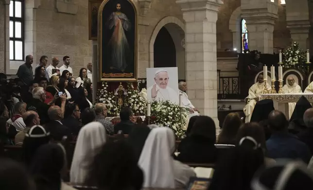 Worshippers attend a memorial mass to commemorate the late Pope Francis at the Church of the Nativity, traditionally believed to be the birthplace of Jesus Christ, in the West Bank town of Bethlehem, Saturday, April 26, 2025. (AP Photo/Mahmoud Illean)