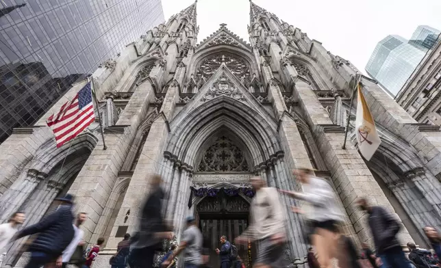 People walk past St. Patrick's Cathedral as dark drapes hang over the doorway before a memorial mass for the late Pope Francis, Saturday, April 26, 2025, in New York. (AP Photo/Julia Demaree Nikhinson)