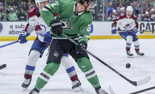 Dallas Stars left wing Mason Marchment (27) and Colorado Avalanche defenseman Ryan Lindgren (55) battle for control of the puck during the first period of Game 5 of a first-round NHL hockey playoff series in Dallas, Monday, April 28, 2025. (AP Photo/Gareth Patterson)