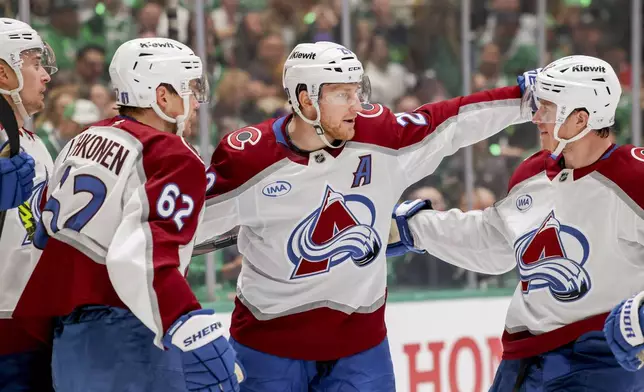 Colorado Avalanche's Artturi Lehkonen (62), Nathan MacKinnon (29) and Josh Manson, right, celebrate after Lehkonen's goal during the second period of Game 5 of a first-round NHL hockey playoff series against the Dallas Stars in Dallas, Monday, April 28, 2025. (AP Photo/Gareth Patterson)