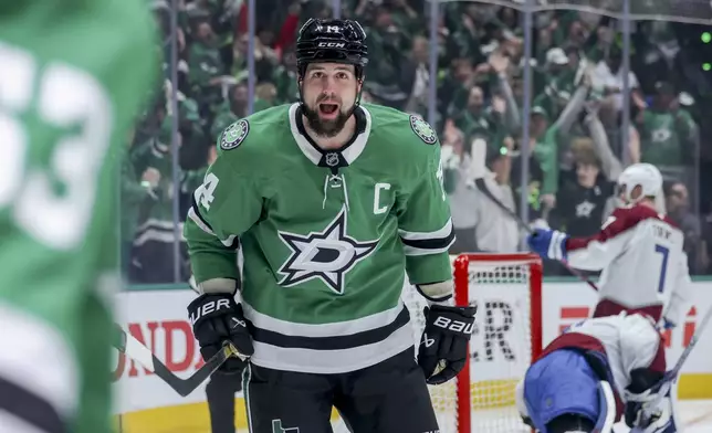 Dallas Stars left wing Jamie Benn (14) celebrates with center Wyatt Johnston, left, after scoring during the first period of Game 5 of a first-round NHL hockey playoff series against the Colorado Avalanche in Dallas, Monday, April 28, 2025. (AP Photo/Gareth Patterson)