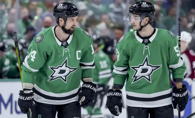 Dallas Stars left wing Jamie Benn, left, and center Wyatt Johnston, right, skate together before a face-off during the first period of Game 5 of a first-round NHL hockey playoff series against the Colorado Avalanche in Dallas, Monday, April 28, 2025. (AP Photo/Gareth Patterson)