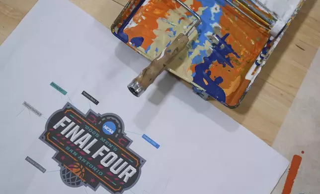 A logo guide and paint tray are seen as workers prepare this year's court for the Final Four in the men’s NCAA college basketball tournament, Sunday, March 16, 2025, in San Marcos, Texas. (AP Photo/Eric Gay)