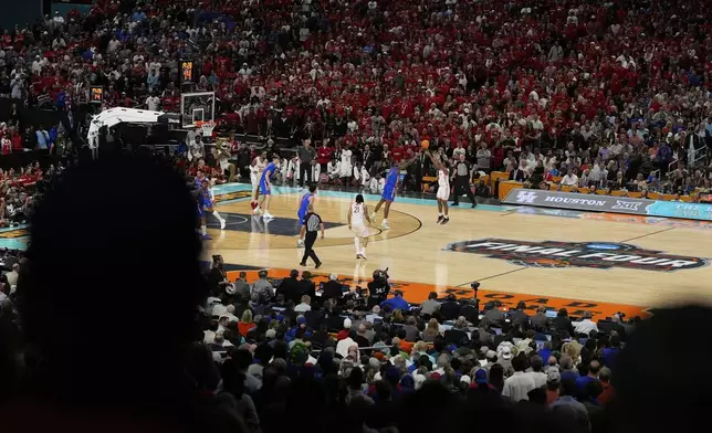 Houston's L.J. Cryer (4) shoots as Florida's Rueben Chinyelu (9) defends during the second half in the national championship at the Final Four of the NCAA college basketball tournament, Monday, April 7, 2025, in San Antonio. (AP Photo/Stephanie Scarbrough)