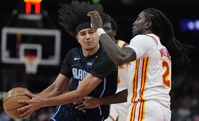Orlando Magic guard Anthony Black (0) drives against Atlanta Hawks guard Keaton Wallace (2) during the first half of an NBA basketball game, Sunday, April 13, 2025, in Atlanta. (AP Photo/Mike Stewart)
