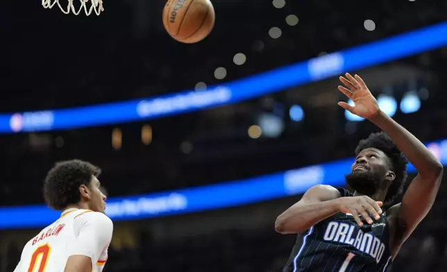Orlando Magic forward Jonathan Isaac (1) shoots against Atlanta Hawks forward Dominick Barlow (0) during the first half of an NBA basketball game, Sunday, April 13, 2025, in Atlanta. (AP Photo/Mike Stewart)