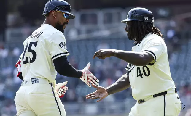 Minnesota Twins' Byron Buxton, left, celebrates his solo home run with third base coach Tommy Watkins during the first inning of a baseball game against the Detroit Tigers Sunday, April 13, 2025, in Minneapolis. (AP Photo/Matt Krohn)