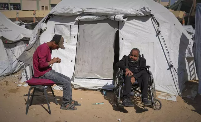 Mohamed Attiya, 54, right, and his son, Wasem, sit in front of their tent before heading to Shifa hospital for a dialysis session in Gaza City, Monday, April 14, 2025. (AP Photo/Jehad Alshrafi)