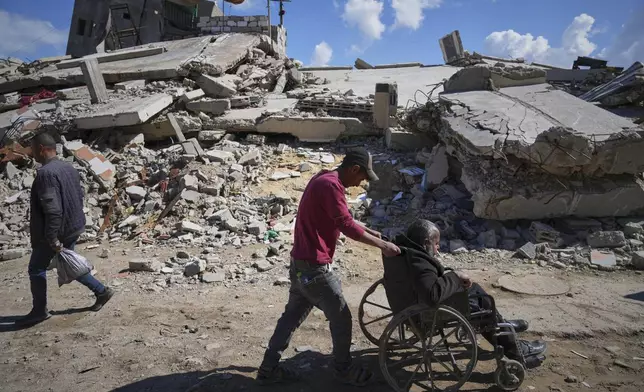 Wasem Attiya pushes his father, Mohamed, 54, in a wheelchair as they head to Shifa hospital in Gaza City for a dialysis session, Monday, April 14, 2025. (AP Photo/Jehad Alshrafi)
