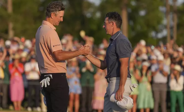 Rory McIlroy, of Northern Ireland, right, greets Justin Rose, of England, after winning in a playoff after the final round the Masters golf tournament, Sunday, April 13, 2025, in Augusta, Ga. (AP Photo/Matt Slocum)