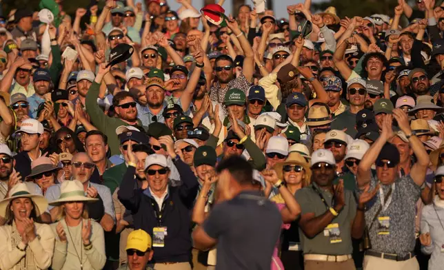 Patrons cheer as Rory McIlroy, of Northern Ireland, celebrates winning in a playoff against Justin Rose, of England, after the final round the Masters golf tournament, Sunday, April 13, 2025, in Augusta, Ga. (AP Photo/Julia Demaree Nikhinson)