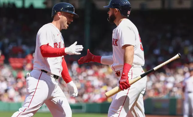 Boston Red Sox's Alex Bregman, left, is greeted by Wilyer Abreu, right, after hitting a home run during the first inning of a baseball game against the Seattle Mariners, Thursday, April 24, 2025, in Boston. (AP Photo/Mark Stockwell)