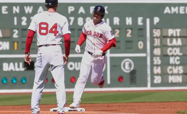 Boston Red Sox's Alex Bregman, right, runs past third base coach Kyle Hudson (84) after hitting a home run during the first inning of a baseball game against the Seattle Mariners, Thursday, April 24, 2025, in Boston. (AP Photo/Mark Stockwell)