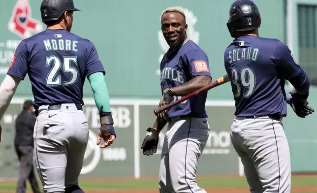 Seattle Mariners' Randy Arozarena, center, walls past teammates Dylan Moore (25) and Seattle Mariners Donovan Solano (39) after hitting a home run during the first inning of a baseball game against the Boston Red Sox, Thursday, April 24, 2025, in Boston. (AP Photo/Mark Stockwell)