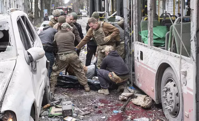 Ukrainian servicemen carry a dead body from a trolleybus after a Russian missile strike on Sumy, Ukraine, Sunday, April 13, 2025. (AP Photo/Volodymyr Hordiienko)