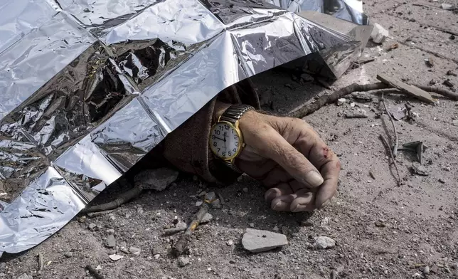 A dead body lies on the ground after a Russian missile strike on Sumy, Ukraine, Sunday April 13, 2025. (AP Photo/Volodymyr Hordiienko)