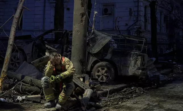 A rescue worker rests near university building destroyed by a Russian missile strike on Sumy, Ukraine, Sunday, April 13, 2025. (AP Photo/Evgeniy Maloletka)