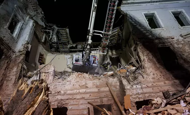 Rescue workers clear the rubble of a university building destroyed by a Russian missile strike on Sumy, Ukraine, Sunday, April 13, 2025. (AP Photo/Evgeniy Maloletka)