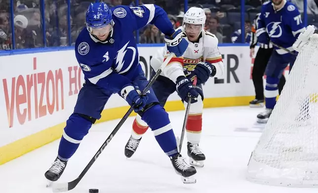Tampa Bay Lightning defenseman Darren Raddysh (43) controls the puck in front of Florida Panthers center Evan Rodrigues (17) during the third period in Game 1 of an NHL hockey Stanley Cup first-round playoff series, Tuesday, April 22, 2025, in Tampa, Fla. (AP Photo/Chris O'Meara)