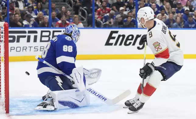 Florida Panthers center Sam Bennett (9) watches his deflection get past Tampa Bay Lightning goaltender Andrei Vasilevskiy (88) for a goal during the first period in Game 1 of an NHL hockey Stanley Cup first-round playoff series, Tuesday, April 22, 2025, in Tampa, Fla. (AP Photo/Chris O'Meara)