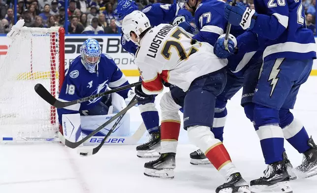 Tampa Bay Lightning goaltender Andrei Vasilevskiy (88) stops a shot by Florida Panthers center Eetu Luostarinen (27) during the first period in Game 1 of an NHL hockey Stanley Cup first-round playoff series, Tuesday, April 22, 2025, in Tampa, Fla. (AP Photo/Chris O'Meara)