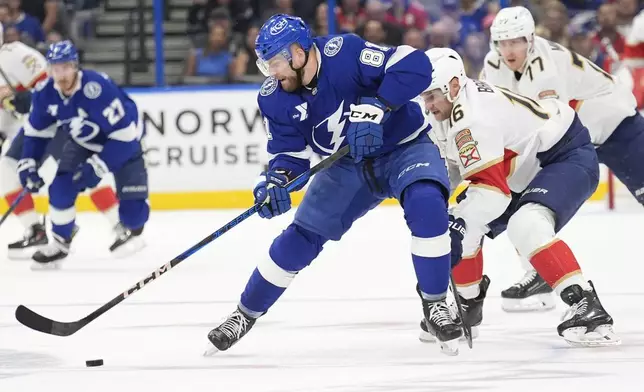 Tampa Bay Lightning defenseman Erik Cernak (81) works the puck in front of Florida Panthers center Aleksander Barkov (16) and defenseman Niko Mikkola (77) during the first period in Game 1 of an NHL hockey Stanley Cup first-round playoff series, Tuesday, April 22, 2025, in Tampa, Fla. (AP Photo/Chris O'Meara)