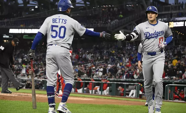 Los Angeles Dodgers designated hitter Shohei Ohtani (17) celebrates after his two-run home run with teammate Mookie Betts (50) during the third inning of a baseball game against the Washington Nationals, Monday, April 7, 2025, in Washington. (AP Photo/Nick Wass)