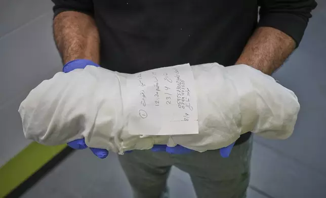 A hospital health worker carries the body of 15-day-old premature infant Sila Zidane, who died from sepsis a few days after her twin sister, following the premature birth of the twins to their mother, Yasmine Zakout, at Nasser Hospital in Khan Younis, southern Gaza Strip, on Wednesday, April 23, 2025. (AP Photo/Abdel Kareem Hana)