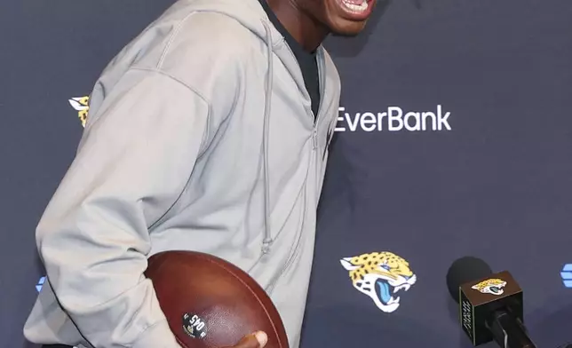 Two-way player Travis Hunter, the Jacksonville Jaguars first round draft pick, second overall, laughs with reporters during an NFL football press conference, Friday, April 25, 2025, in Jacksonville, Fla. (AP Photo/Gary McCullough)