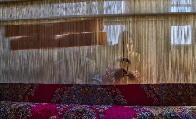 Shameema and her husband Mohammad Yousaf Dar weave a Kashmiri hand-knotted carpet at their home in Srinagar, Indian controlled Kashmir, on April 15, 2025. (AP Photo/Dar Yasin)