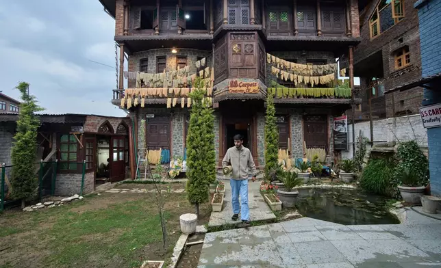 Ahsan Sofi carries a Kashmiri hand-knotted carpet out of a carpet factory in Srinagar, Indian controlled Kashmir, on April 9, 2025. (AP Photo/Dar Yasin)
