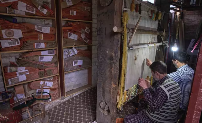 Farooq Ahmed, left, and Mushtaq Ahmed weave a Kashmiri hand-knotted carpet at a factory in Srinagar, Indian controlled Kashmir, on April 9, 2025. (AP Photo/Dar Yasin)