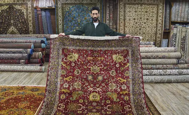 Mohammad Iqbal Bakshi displays a Kashmiri hand-knotted silk carpet at a showroom in Srinagar, Indian controlled Kashmir, on April 14, 2025. (AP Photo/Dar Yasin)
