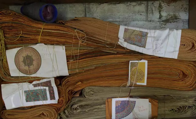 Decades-old instruction manuals of carpet designs known as Taleem are stacked on a shelf at a carpet factory in Srinagar, Indian controlled Kashmir, on April 9, 2025. (AP Photo/Dar Yasin)