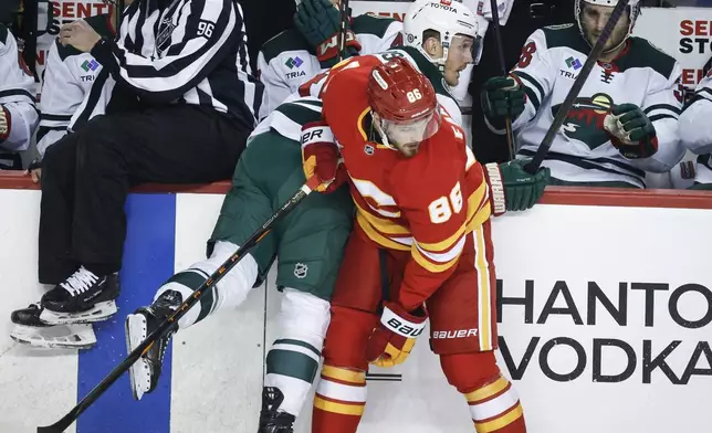 Minnesota Wild's Gustav Nyquist (41) is checked by Calgary Flames' Joel Farabee (86) during the first period of an NHL hockey game in Calgary, Alberta, Friday, April 11, 2025. (Jeff McIntosh/The Canadian Press via AP)