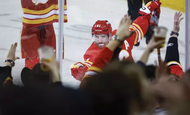 Calgary Flames' Nazem Kadri (91) celebrates his goal as fans cheer during the second period of an NHL hockey game against the Minnesota Wild in Calgary, Alberta, Friday, April 11, 2025. (Jeff McIntosh/The Canadian Press via AP)