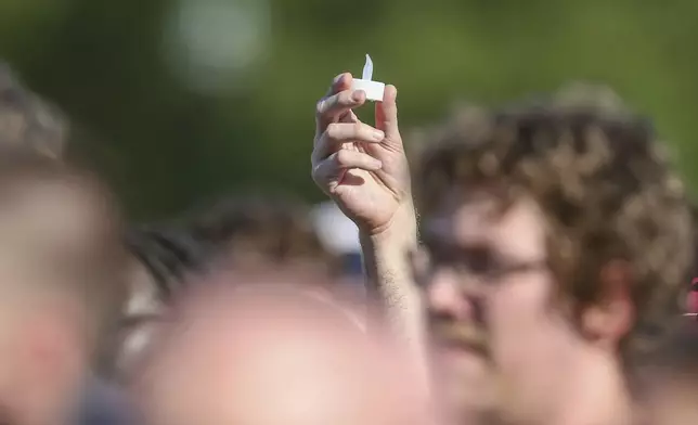 Electronic candles are lifted during a vigil on the Florida State campus at Langford Green, Tallahassee, Fla., Friday, April 18, 2025. (AP Photo/Gary McCullough)