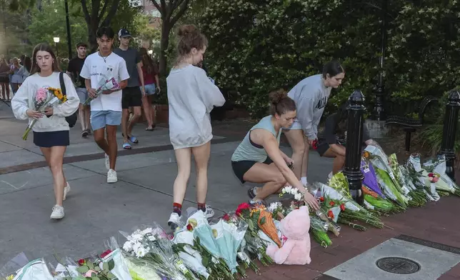 An impromptu memorial shared online brings students bearing flowers near the center of the Florida State campus in sight of the Student Union building, Tallahassee, Fla., Thursday, April 17, 2025. (AP Photo/Gary McCullough)